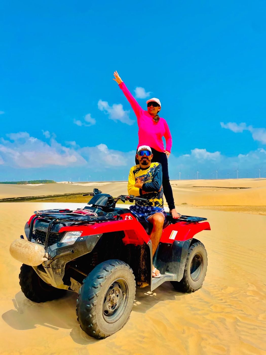Amigos em quadriciclo sobre as dunas de areia